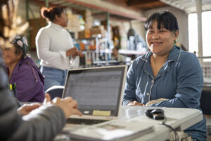 Photo of food pantry client smiling at the assistance registration table.