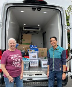 Photo of truck with food pick up and two people, Janelle Morimoto and San Lorenzo Japanese Christian Church representative.