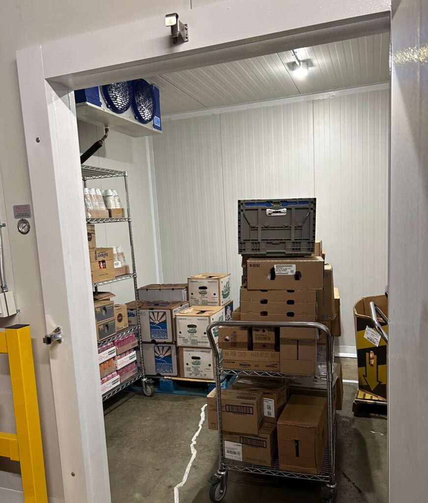 Photo of inside a walk-in refrigeration with food boxes.